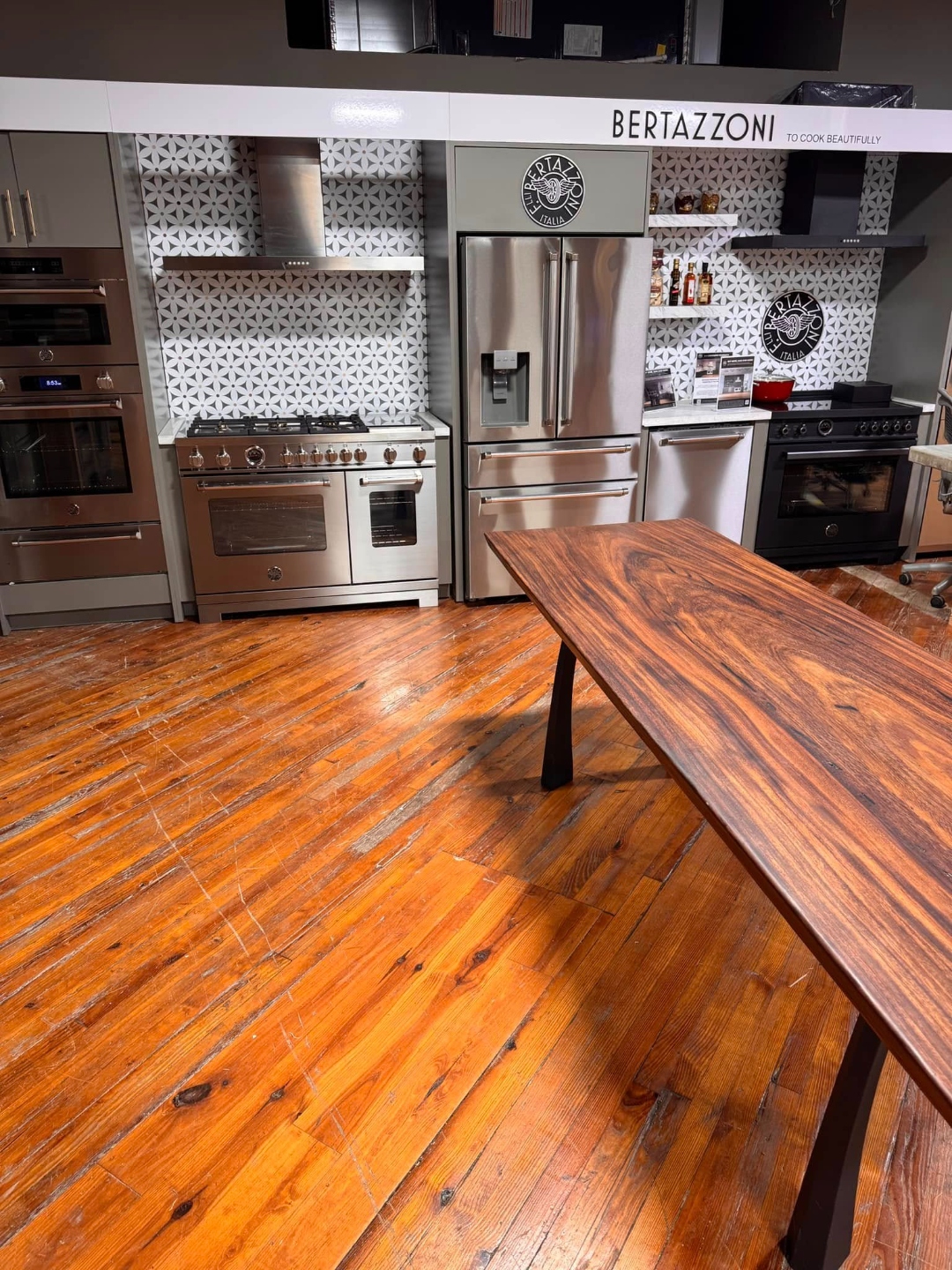 Long live-edge wood table on black steel legs in a kitchen showroom, from our Statham, GA shop