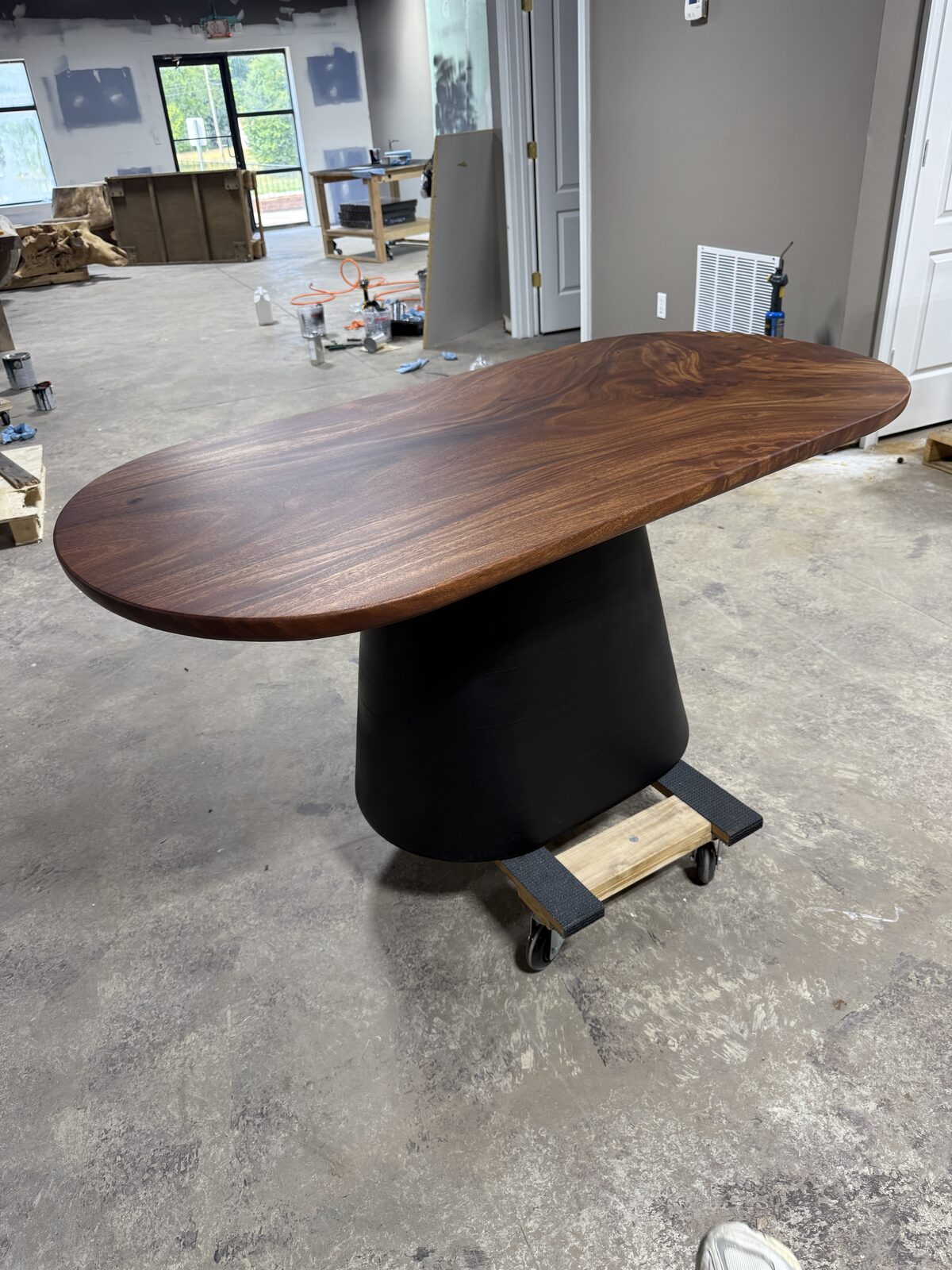 Dark walnut oval table top on a black pedestal base