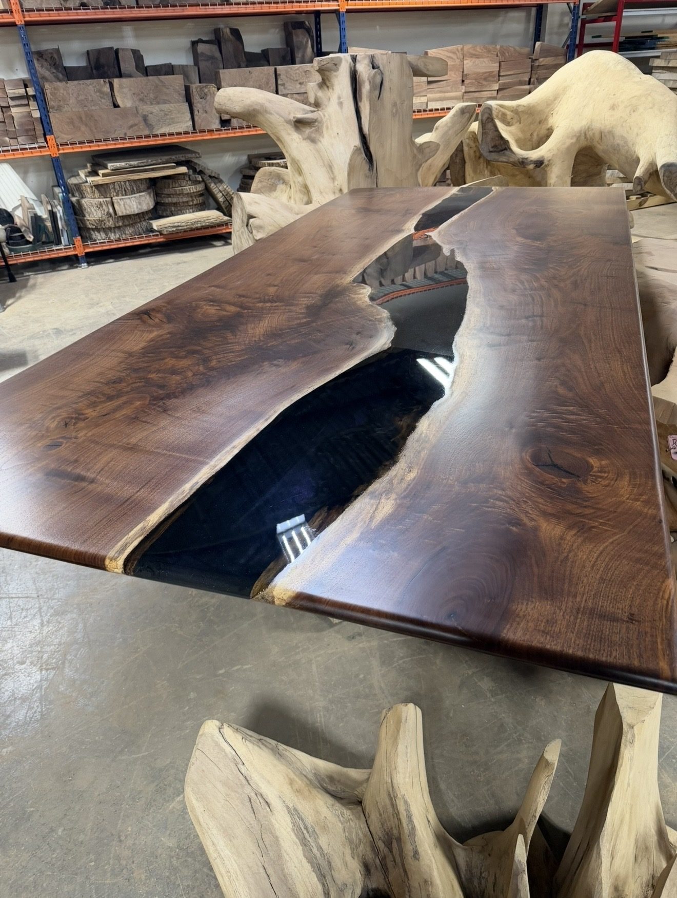 Black walnut table top with a black epoxy river in the workshop