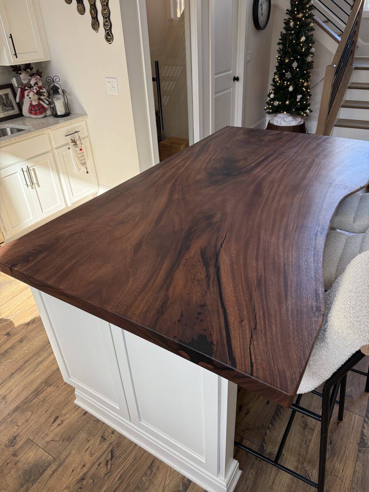 Dark walnut live-edge slab top on a white kitchen island
