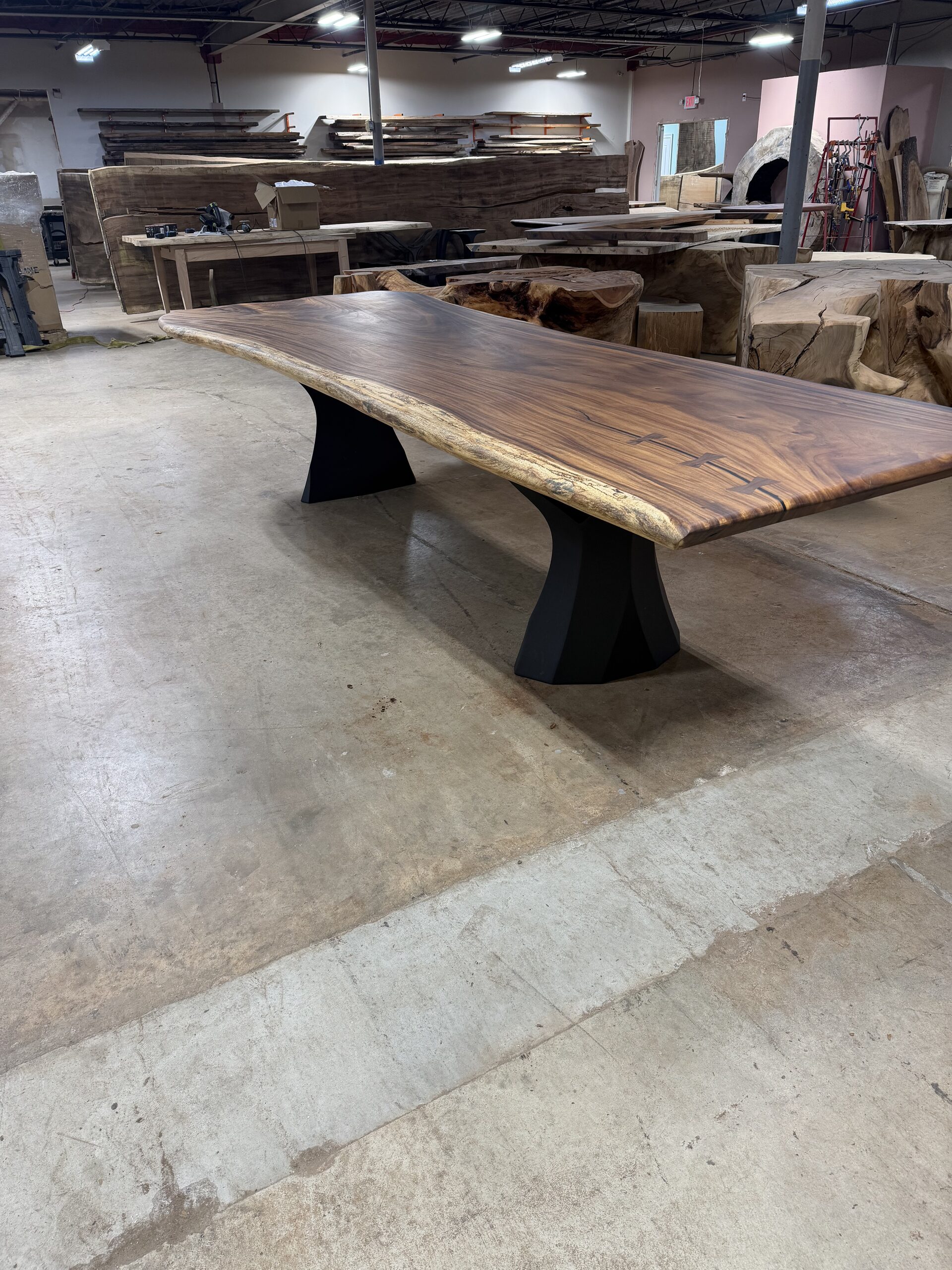 Live-edge slab table top with butterfly joinery on a black steel base