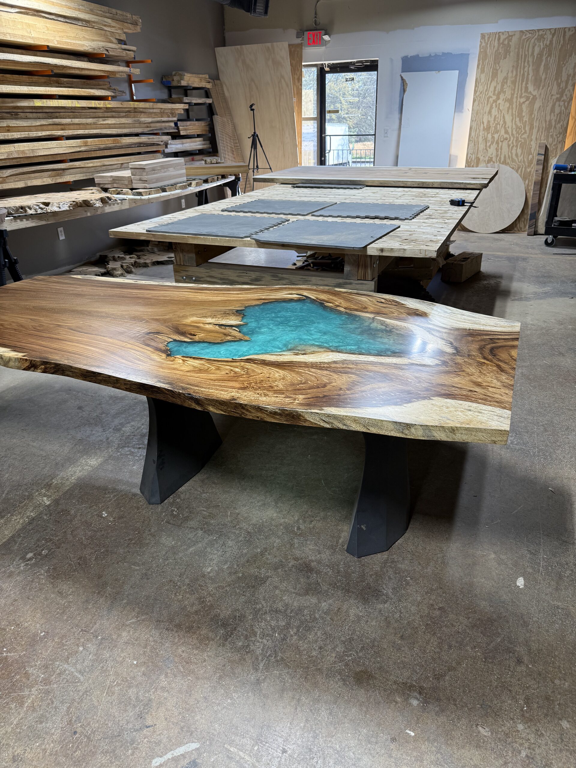 Live-edge table with a turquoise resin lake inlay on black steel legs